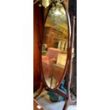 Mahogany framed oval cheval mirror on turned supports and splayed legs with brass caps and