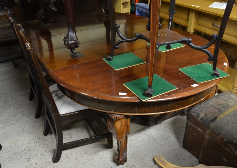 A large mahogany extending dining table, the rounded top with moulded edge and two central leaves