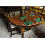 A large mahogany extending dining table, the rounded top with moulded edge and two central leaves