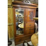 An early 20th century carved mahogany compactum with bevelled mirrored door, panelled door and