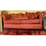 A pair of large scroll arm Knoll two seater sofas in red damask upholstery, with turned wooden