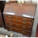 A George III oak fall front bureau with fitted interior over four long graduating drawers with brass