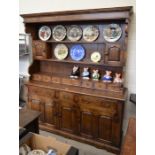 A large oak dresser, the raised back with small cupboards and seven fitted drawers over a base
