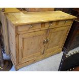 Antique waxed pine dresser base with three drawers over panelled cupboard doors