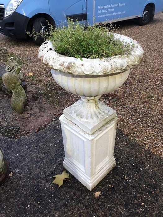 A pair of weathered stonecrete garden urns raised on square plinths, later painted (2) - Image 2 of 3