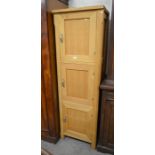 A modern beech hall cupboard with three panelled doors