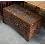 An Oriental heavily carved hardwood and camphor lined blanket chest