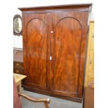 A large 19th century mahogany linen press, the pair of full length arch panelled doors enclosing