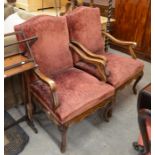 A pair of French carved mahogany armchairs, with burgundy upholstery