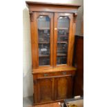 Figured walnut cabinet bookcase with a pair of glazed doors enclosing shelves, over a base with