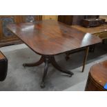 A Regency mahogany breakfast table, the rectangular tilt top on a turned column and quad supports