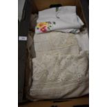 A box of assorted table linen to include embroidered tablecloths etc.