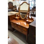 A mahogany and crossbanded dressing table, the raised back with bevelled shield shaped mirror and
