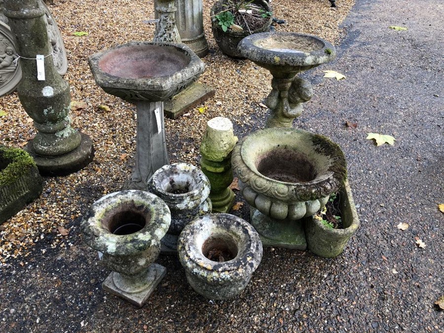 A selection of assorted cast stone garden items including two birdbaths, marble urns, a small trough