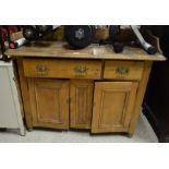 An old pine sideboard with galleried back over two drawers and panelled cupboard doors