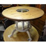 A circular pine top glass panelled breakfast table raised on a painted platform base