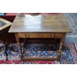 A 17th/18th century oak side table, the two plank top over a frieze drawer, raised on turned