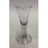 An 18th century wine glass with drawn trumpet bowl, plain stem, conical fold over foot and rough