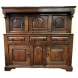 An 18th century joint oak court cupboard, with fielded panel doors flanking a dated center panel