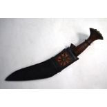 A Nepalese Gurkha kukri with brass-mounted wood handle and 26 cm engraved blade and leather