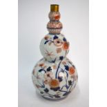 A Japanese Imari vase of gourd form, decorated in underglaze blue, orange and gilt with floral