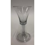 An 18th century wine glass with trumpet bowl, solid base with tear drop extending into the plain