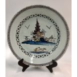 An 18th century English Delft polychrome dish decorated in the Chinoiserie style with a house on