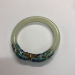A Chinese jade bangle with applied enamel decoration, 8 cm diamGood condition, no damage
