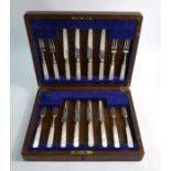 An oak-cased set of eight each silver dessert knives and forks with mother-of-pearl handles, James