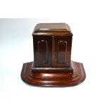 A Victorian walnut three drawer table top cabinet, with pair of arched panel doors, raised on a