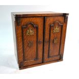 A Victorian oak novelty smoker's cabinet in the form of a safe, with twin panelled doors enclosing