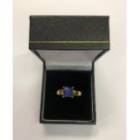 A contemporary 18ct yellow gold ring set with square cut tanzanite, size O, approx 4.7g all in