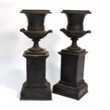 A pair of Regency bronzed garniture urns on honeysuckle-carved slate plinths, 25 cm highChips to