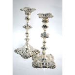 A matched pair of George III cast silver baluster candlesticks with foliate and shell designs, on