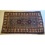 An antique Caucasian rug, centered by a row of diamond lozenges on blue ground, 2.20 cm x 1.26 cm