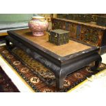 A Chinese rattan panelled lacquered hardwood daybed in the Ming style, raised on four scroll feet,