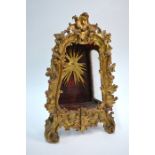 An 18th/19th century giltwood monstrance in the rococo style, the glazed side panels enclosing a