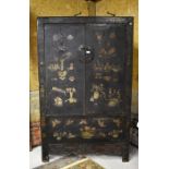 A Chinese lacquered wood cabinet with two typical hinged doors and central metal lock; decorated