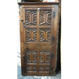 A 17th century style joint oak corner cupboard, having two tiers of twin doors, each with relief