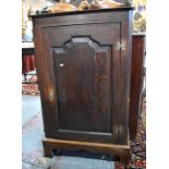 An 18th century and later oak cupboard, with fret cut gallery to top over a single panelled door