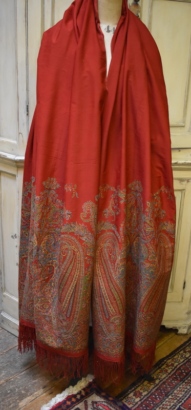 An early/mid 19th century deep red woollen shawl produced in Paisley, Scotland with deep paisley