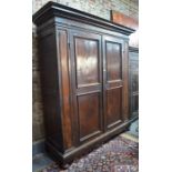 A substantial 18th century Palazzo scale Florentine fruitwood armoire, the dentil moulded canopy top