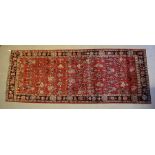 An old Persian Mahal rug, the repeating lattice design on mid-red ground, approx 3.05 x 1.20 m