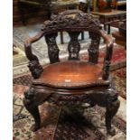 A Chinese carved hardwood open armchair profusely carved with entwined dragons and foliage circa