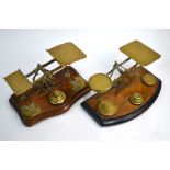 Two pairs of brass postage scales and weights on wooden bases