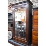 A continental rosewood and kingwood armoire with large single mirror panelled door, enclosing