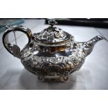 A William IV silver teapot, richly chased and embossed with flowers, foliage and scrolls, George