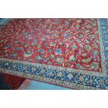 A large old Persian Ispahan carpet, the all-over design of flowering tendrils on mid-red ground