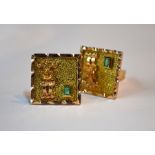 A pair of yellow metal contemporary cufflinks with textured decoration and applied figure, each
