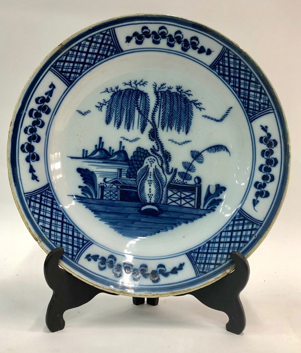 An 18th century English Delft blue and white shallow dish decorated in the Chinoiserie style with